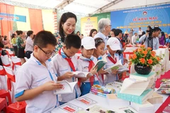 (Đông đảo học sinh đến tham dự và đọc sách tại Ngày hội. (Ảnh: Hoàng Ngà/TTXVN)