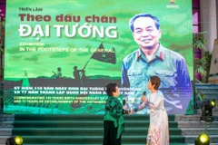 Nhà thơ Nguyễn Thị Mỹ Dung (trái) và ca sỹ Mỹ Linh ngẫu hứng trong lễ khai mạc triển lãm. (Ảnh: Minh Sơn/Vietnam+)