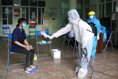 Phóng viên kênh truyền hình Thông tấn VNews tác nghiệp tại khu vực có nguy cơ lây nhiễm. (Ảnh: Quốc Dũng/TTXVN) 