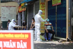 Lực lượng y tế quận Hai Bà Trưng lấy mẫu xét nghiệm cho người dân phố Tô Hiến Thành. (Ảnh: Hoàng Hiếu/TTXVN)