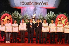Thủ tướng Nguyễn Xuân Phúc trao bằng Tổ quốc ghi công cho thân nhân các gia đình liệt sỹ. (Ảnh: Thống Nhất/TTXVN)