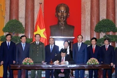 Chủ tịch nước Trương Tấn Sang Ký‎ Lệnh công bố Hiến pháp nước CHXHCN Việt Nam và Lệnh công bố Nghị quyết quy định một số điểm thi hành Hiến pháp nước CHXHCN Việt Nam. (Ảnh: Nguyễn Khang/TTXVN)