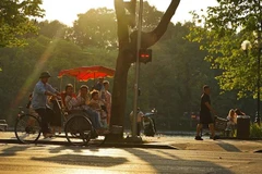 Du khách trải nghiệm du lịch quanh hồ Hoàn Kiếm bằng xích lô. (Ảnh: Khánh Hòa/TTXVN)