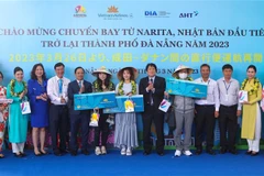 Ban tổ chức trao tặng vé khứa hồi cho hành khách may mắn trên chuyến bay đầu tiên từ Narita (Nhật Bản) đến Đà Nẵng. (Ảnh: Trần Lê Lâm/TTXVN)