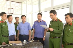 Cơ quan điều tra đọc lệnh khám xét tại nơi làm việc của Nguyễn Văn Chiến. (Ảnh: TTXVN phát)