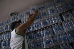 Người dân mua nước đóng chai. (Ảnh: AFP/TTXVN)