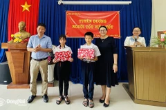 Phó giám đốc Sở Giáo dục và Đào tạo Đồng Nai Đỗ Đăng Bảo Linh trao giấy khen cho em Lê Nhã Trâm và Nguyễn Quốc Kỳ. (Nguồn: Báo Đồng Nai)