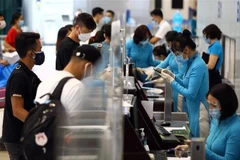 Hành khách làm thủ tục lên máy bay tại quầy của hãng hàng không Vietnam Airline. (Ảnh: Huy Hùng/TTXVN)
