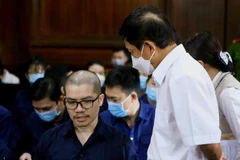 Bị cáo Nguyễn Thái Luyện trao đổi với luật sư tại phiên tòa sơ thẩm. (Ảnh: Thành Chung/TTXVN)