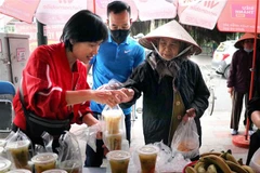 Anh chị em tổ cơm từ thiện bán các suất cơm từ thiện tới người có hoàn cảnh khó khăn. (Ảnh: Hoàng Ngọc/TTXVN)