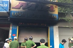 Lực lượng chức năng đã giải cứu kịp thời ba người trong cửa hàng bị cháy. (Ảnh: Thành Chung/TTXVN)