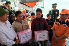 Đại diện Cục Hàng hải Việt Nam và Bộ Giao thông vận tải tặng quà cho các ngư dân sau khi lên bờ an toàn. (Ảnh: Tá Chuyên/TTXVN)