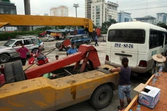 Di chuyển xe vi phạm tại một bến cóc ở khu vực gần bến xe Mỹ Đình. (Ảnh: Huy Hùng/TTXVN)