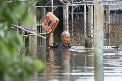 Ông Nguyễn Văn Lộc ở thôn Thượng Phú, xã Tượng Sơn, huyện Thạch Hà lội nước đi nhận hàng cứu trợ. (Ảnh: Minh Quyết/TTXVN)