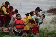 Sơ tán người dân khỏi các khu vực ngập lụt do mưa lớn sau bão Eta tại El Progreso, Honduras. (Ảnh: AFP/TTXVN)