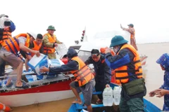 Đoàn cứu trợ của Trung ương Hội Chữ thập đỏ Việt Nam mang những phần quà thiết thực đến tay người dân vùng lũ xã Hàm Ninh, huyện Quảng Ninh, Quảng Bình. (Ảnh: Võ Dung/TTXVN)