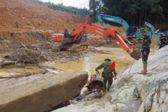 Tập trung tìm kiếm các nạn nhân ở dưới lòng suối Rào Trăng. (Ảnh: TTXVN phát)