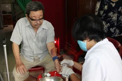 Điều dưỡng Trạm Y tế phường 16, quận Gò Vấp đến nhà lấy máu xét nghiệm cho người bệnh. (Ảnh: Đinh Hằng/TTXVN)