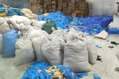 Hiện trường số găng tay cao su không đảm bảo chất lượng. (Ảnh: TTXVN phát)