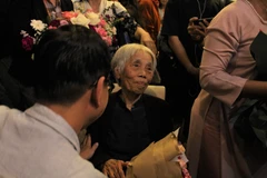 Họa sỹ Mộng Bích trong triển lãm 'Đi giữa hai thế kỷ.' (Ảnh: Minh Anh/Vietnam+)