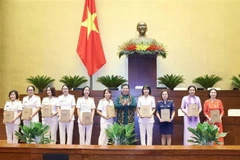 Ủy viên Bộ Chính trị, Phó Chủ tịch Thường trực Quốc hội Tòng Thị Phóng tặng quà lưu niệm cho các đại biểu dự buổi gặp mặt. (Ảnh: Phương Hoa/TTXVN)