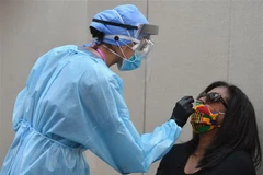 Nhân viên y tế lấy mẫu xét nghiệm COVID-19 tại New York, Mỹ. (Ảnh: AFP/TTXVN)