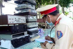 Lực lượng Công an kiểm tra tang vật thu giữ. (Ảnh: TTXVN phát)