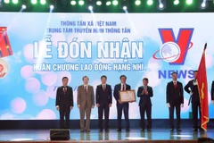 Tổng Giám đốc Thông tấn xã Việt Nam Nguyễn Đức Lợi trao Huân chương Lao động hạng Nhì của Chủ tịch nước tặng Trung tâm Truyền hình Thông tấn. (Ảnh: Phan Tuấn Anh/TTXVN)