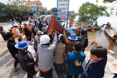  Các ngư dân chuyển thuyền đi biển xuống vùng lũ tại huyện Lệ Thủy hỗ trợ công tác cứu trợ đồng bào. (Ảnh: Thành Đạt/TTXVN)