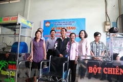 Ban vận động vì người nghèo quận 11, TP.HCM trao tặng phương tiện sinh kế cho hộ nghèo, hộ cận nghèo tại địa phương. (Ảnh: TTXVN)