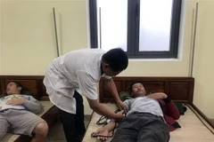 Bác sỹ quân y của Đồn Biên phòng Vinh Hiền chăm sóc sức khỏe cho thuyền viên tàu hàng Công Thành 27. (Ảnh: TTXVN phát)