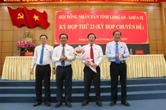 Ông Nguyễn Văn Út (người cầm hoa) được bầu giữ chức vụ Chủ tịch UBND tỉnh Long An, nhiệm kỳ 2016-2021. (Ảnh: Thanh Bình/TTXVN)