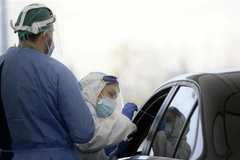 Nhân viên y tế lấy mẫu xét nghiệm COVID-19 tại Rome, Italy. (Ảnh: AFP/TTXVN)