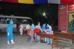Công dân làm thủ tục vào cơ sở cách ly. (Ảnh: Đinh Tuấn/TTXVN)