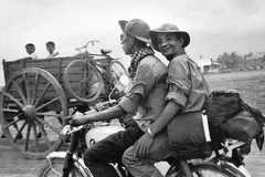 Phóng viên TTXGP Nguyễn Đức Giáp (người ngồi sau) cùng đồng nghiệp trên đường tiến về Sài Gòn trong chiến dịch Hồ Chí Minh, tháng 4/1975. (Ảnh: Tư liệu TTXGP)