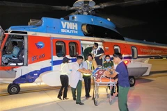 Hai bệnh nhân được đưa về đến Sân bay Tân Sơn Nhất, Thành phố Hồ Chí Minh tối 22/10. (Ảnh: TTXVN phát)