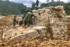 Lực lượng công binh phá khối bêtông cốt thép lớn tại vị trí sạt lở vui lấp các công nhân. (Ảnh: TTXVN phát)