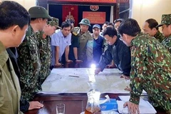 Chủ tịch UBND huyện Phong Điền Nguyễn Văn Bình (sơ mi ngắn tay xanh nhạt) họp bàn trước lúc lên đường cứu trợ đoàn công nhân mất tích tại Thủy điện Rào Trăng 3. (Ảnh: TTXVN phát)