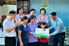Ông Ngô Công Thắng - Giám đốc Nhà máy sữa Vinamilk Nghệ An đại diện công ty và Quỹ sữa Vươn cao Việt Nam thăm hỏi gia đình và trao tặng học bổng trị giá 50 triệu đồng để hỗ trợ chị em Đạt. (Nguồn: Vietnam+)