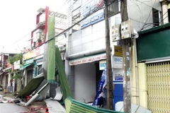 Bão số 9 với sức gió mạnh gây tốc mái nhà dân, giật tung nhiều biển quảng cáo trên đường phố Quảng Ngãi. (Ảnh: Lê Ngọc Phước/TTXVN)