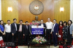 Chủ tịch Ủy ban Trung ương MTTQ Việt Nam Trần Thanh Mẫn tiếp nhận ủng hộ đồng bào miền Trung từ tập thể cán bộ, công chức, viên chức, người lao động Thông tấn xã Việt Nam. (Ảnh: Dương Giang/TTXVN)