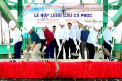 Các đại biểu thực hiện nghi lễ hợp long cầu Cổ Phúc. (Ảnh: TTXVN phát)