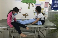 Các em học sinh nhập viện với các triệu chứng ngộ độc sau khi uống trà sữa. (Ảnh: TTXVN phát)