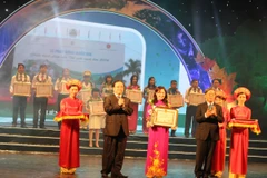 Phó Thủ tướng Hoàng Trung Hải và Bộ trưởng Tài nguyên-Môi trường Nguyễn Minh Quang trao kỷ niệm chương cho các tập thể điển hình tiên tiến. (Ảnh: Hùng Võ/Vietnam+)