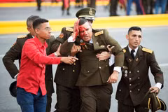 Lực lượng an ninh Venezuela hỗ trợ một đồng đội bị thương rời khỏi hiện trường vụ tấn công tại lễ kỷ niệm Ngày Quốc phòng ở thủ đô Caracas ngày 4/8. (Nguồn: THX/TTXVN)