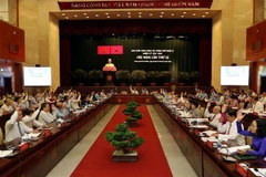 Các đại biểu biểu quyết, thông qua Nghị quyết hội nghị. (Ảnh: Thanh Vũ/TTXVN)