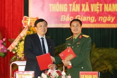 Giám đốc Truyền hình Thông tấn Nguyễn Thiện Thuật và Thượng tá Nguyễn Thành Phố, Sư đoàn trưởng Sư đoàn 325 ký biên bản kết nghĩa. (Ảnh: Dương Giang/TTXVN)