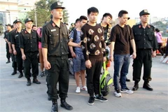 Công an tỉnh Lào Cai bàn giao các đối tượng cho Công an Trung Quốc tại Cửa khẩu Quốc tế Lào Cai. (Ảnh: Hồng Ninh/TTXVN)