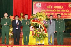 Tổng Giám đốc TTXVN Nguyễn Đức Lợi tặng hoa chúc mừng Bộ Tư lệnh Quân đoàn 2. (Ảnh: Dương Giang/TTXVN)