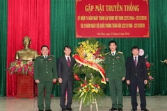 Tổng giám đốc TTXVN Nguyễn Đức Lợi tặng hoa chúc mừng Sư đoàn 304. (Ảnh: Văn Điệp/TTXVN)